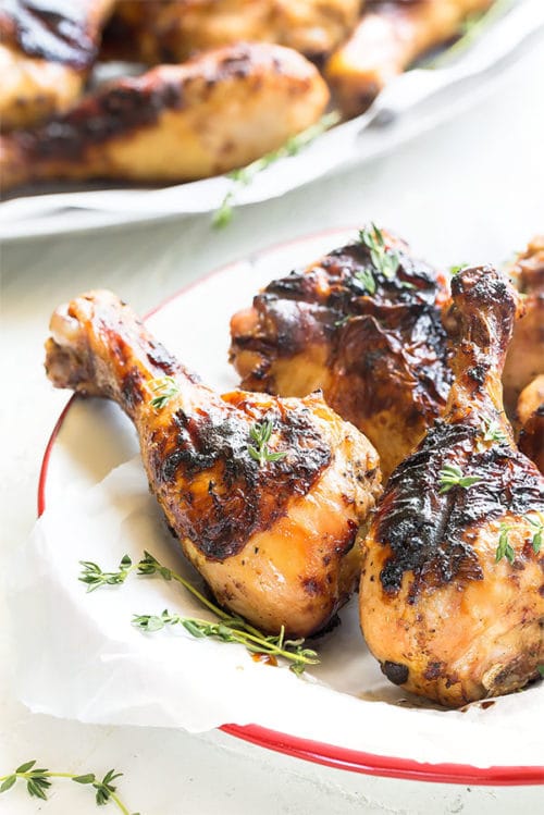 Marinated in an authentic Jamaican jerk sauce, these tender juicy homemade jerk chicken drumsticks are the best you'll ever make. While it does require an advance prep, you'll love the easy almost hands-off cooking on a week night while the chicken slowly cooks on the grill. #chickendrumsticks #jerkchicken #jamaicanjerksauce #jamaicanjerkchicken #jamaicanjerkmarinade #grilledchicken #busycooks