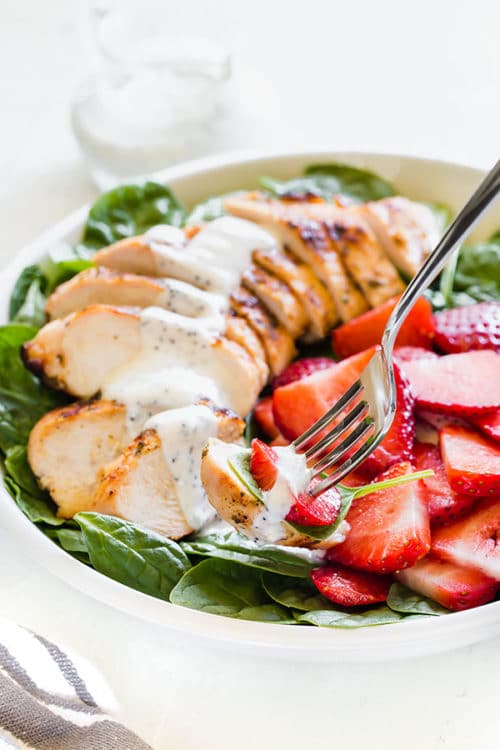 Satisfying strawberry spinach salad with grilled chicken and creamy poppy seed dressing is a perfect weeknight dinner on a hot summer day. The dressing can be prepared in advance, grilling the chicken takes less than 30 minutes, which means you can toss this salad together in less than 45 minutes! #chickensalad #strawberryspinachsalad #salad #summersalad #weeknightmeal #easydinner #poppyseeddressing #busycooks