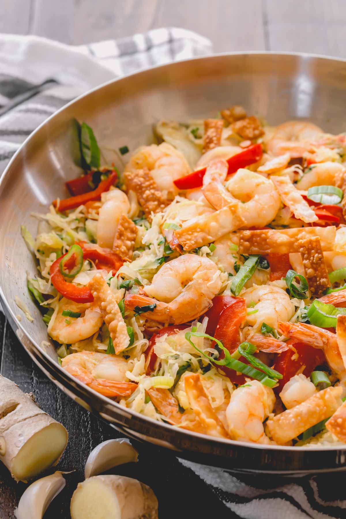 Shrimp and cabbage stir fry in a skillet.