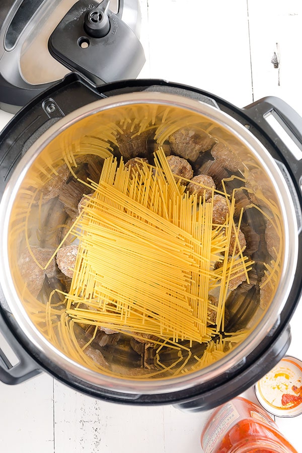 Frozen meatballs and spaghetti criss-crossed on top in an Instant Pot. 