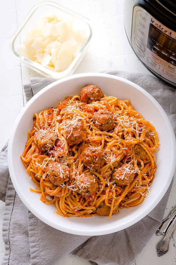 A bowl of Instant Pot spaghetti and meatballs with parmesan. 