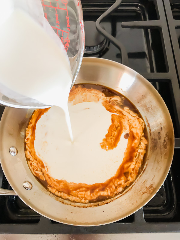 Heavy cream being poured into a skillet. 