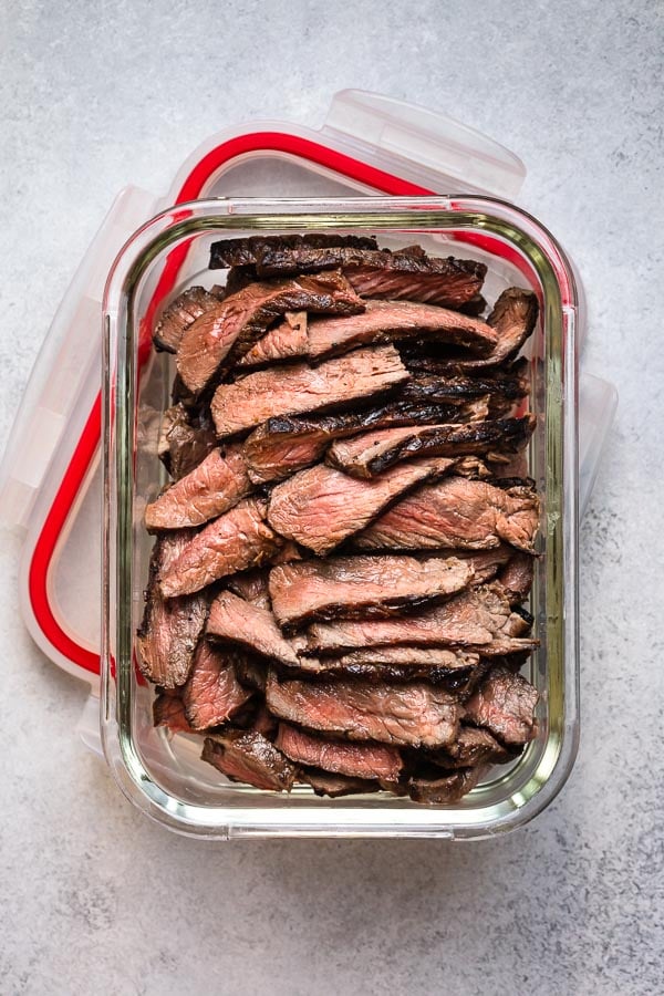 Cooked sliced steak in an airtight container. 