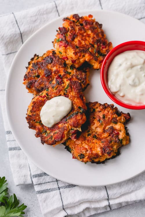 Repurpose leftover baked salmon into flavorful tender salmon cakes. Jarred roasted red pepper is the main secret to the burst of flavor in this quick and easy cook-once eat-twice meal. #salmoncakes