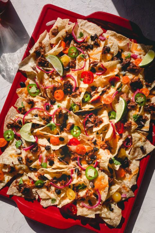 Here's the best nachos recipe around!  Making the best nachos is less about how much ingredients to use, and is more about layering the ingredients properly for the best possible result. #nachos #bestnachos #pulledporknachos