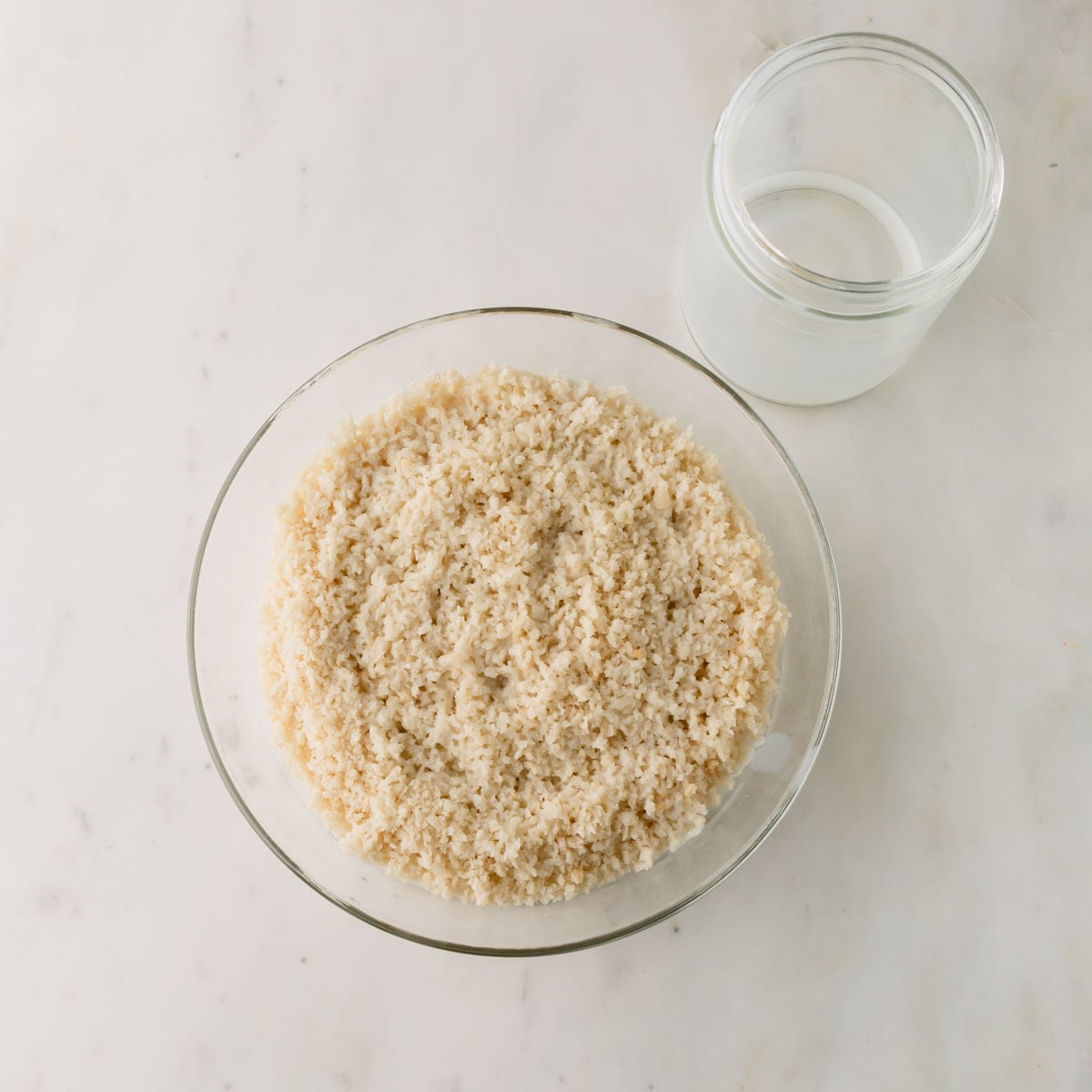 Panko breadcrumbs in a glass bowl soaked in milk.