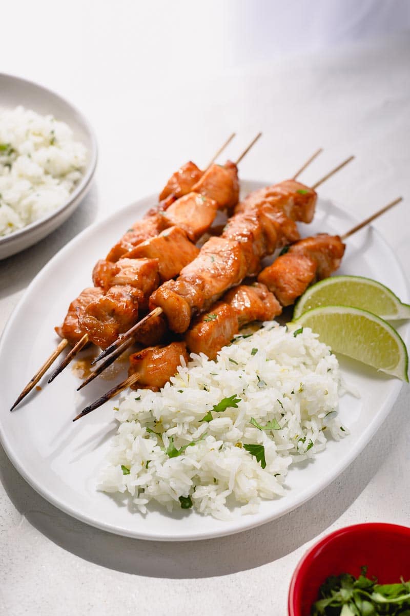A plate of chicken skewers and cilantro lime rice. 