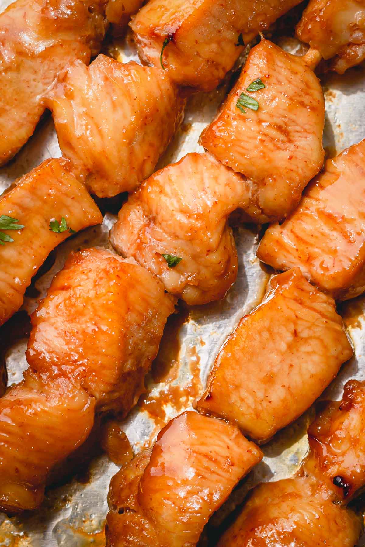 Cooked chicken skewers on a baking sheet.