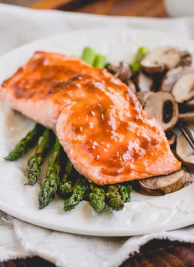 Apricot salmon filet over a bed of asparagus and mushrooms.