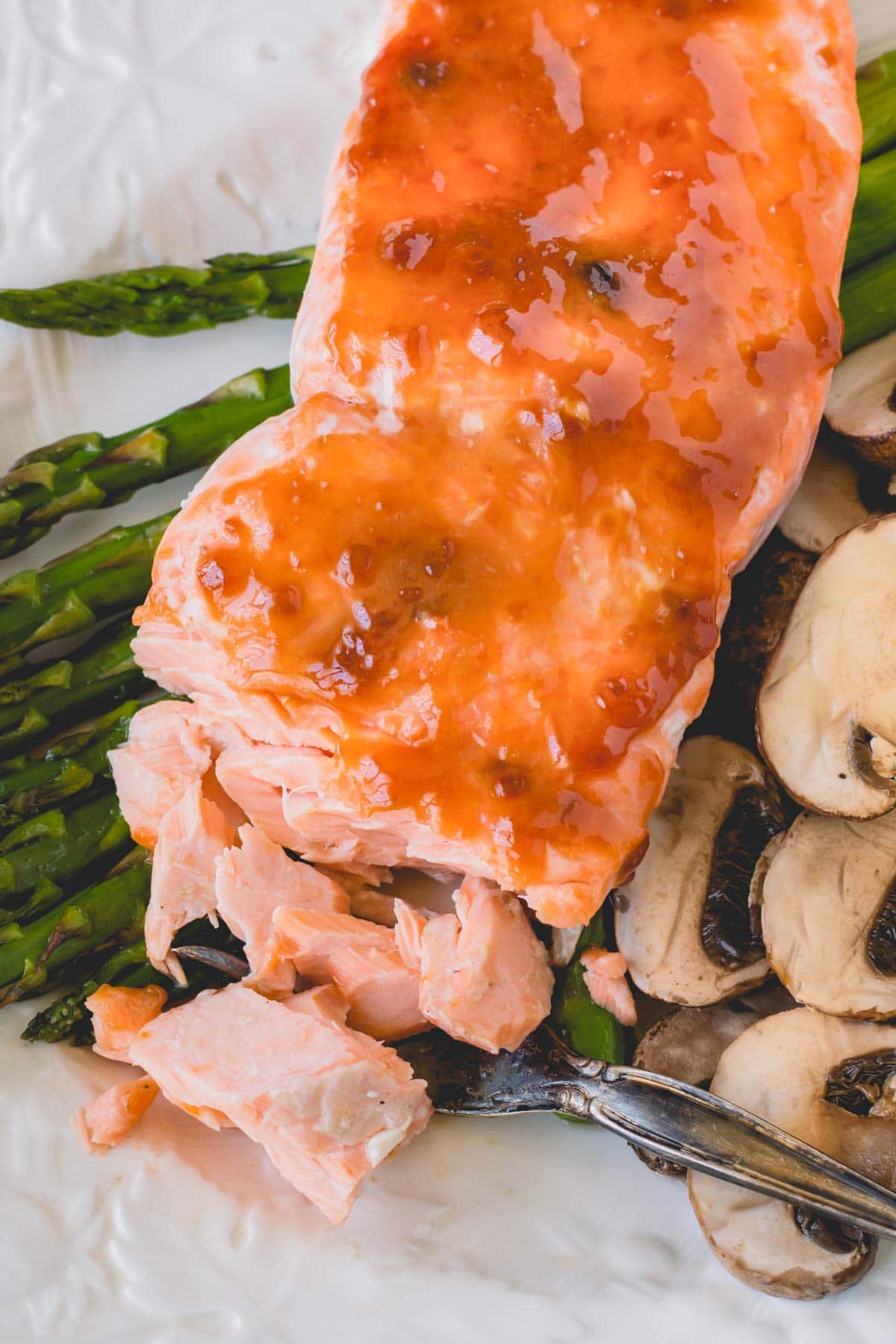 Flaked baked salmon over asparagus and mushrooms