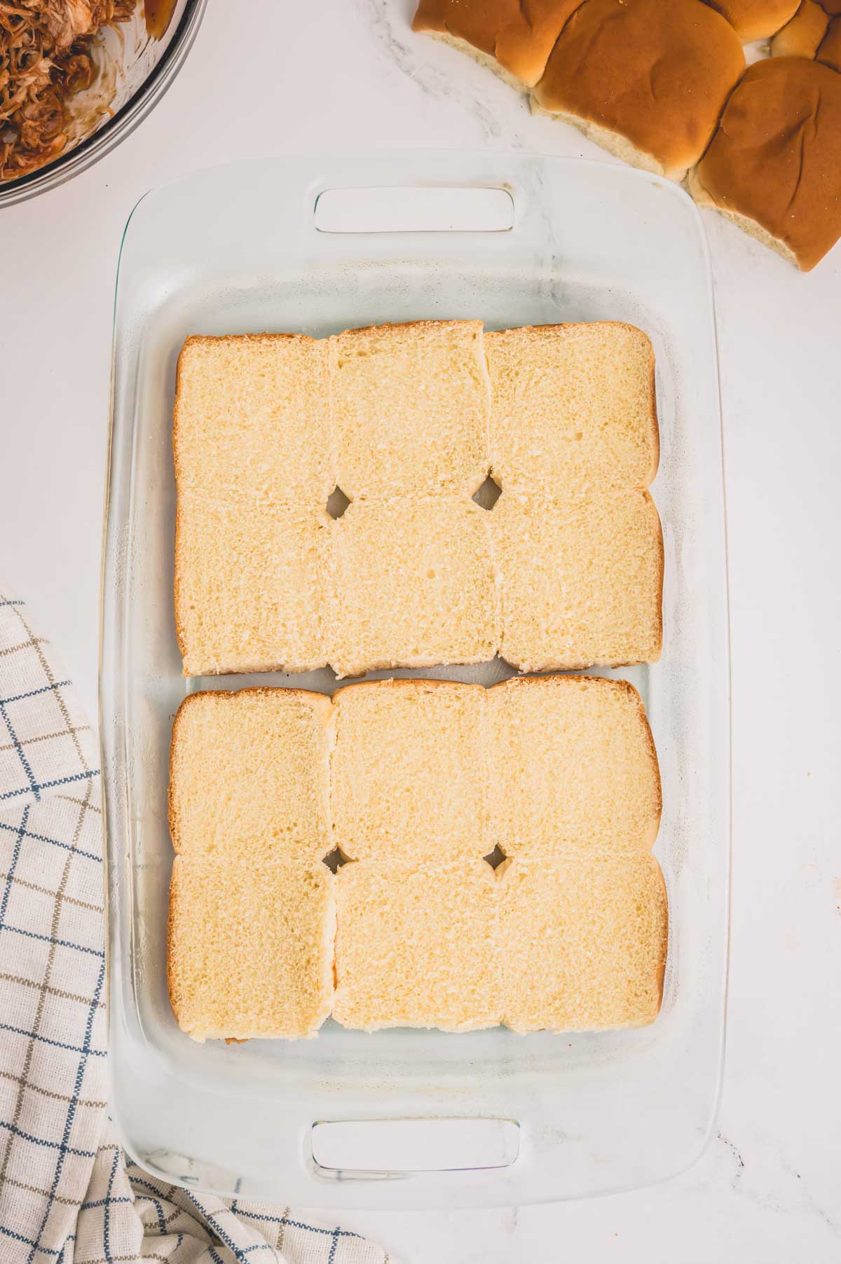 Glass baking sheet with a bottom side of 12 slider rolls.