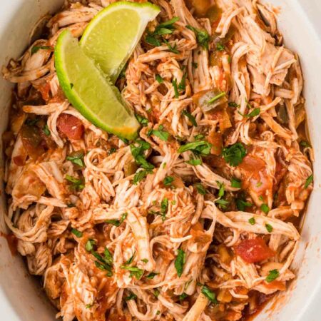 a crockpot with shredded chicken and salsa