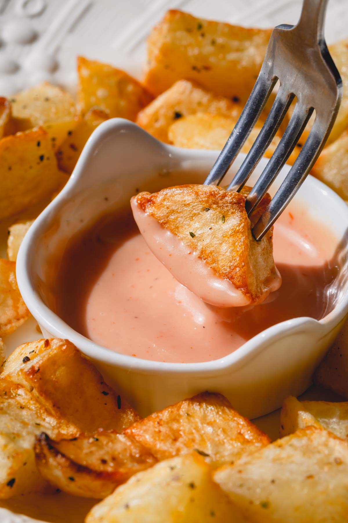 fork dipping potato into chipotle mayo. 