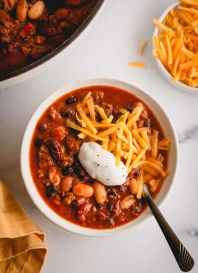 a bowl of chili with cheese and sour cream.