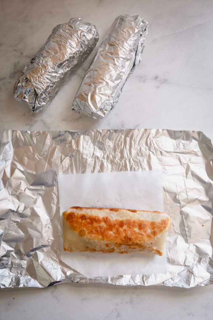 cooked breakfast burrito on a piece of foil.