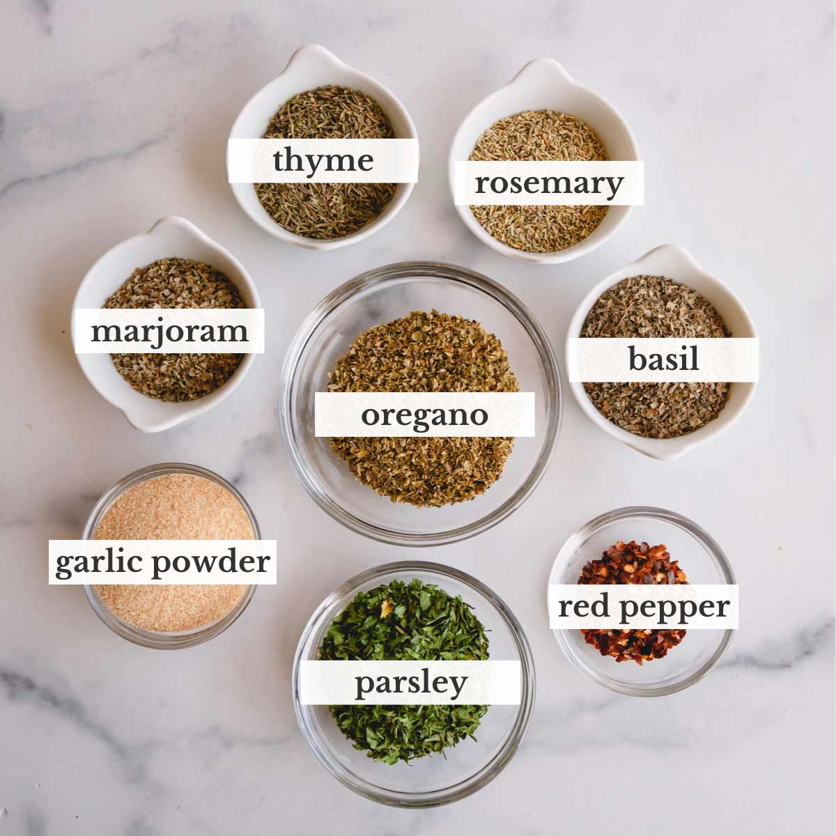 Small bowls of herbs and spices to make homemade Italian seasoning.