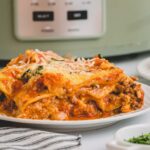 A serving of slow cooker lasagna on a white plate.