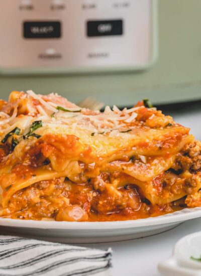 A serving of slow cooker lasagna on a white plate.