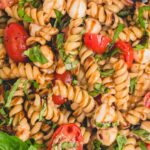 Overhead image of Caprese pasta salad topped with balsamic glaze.