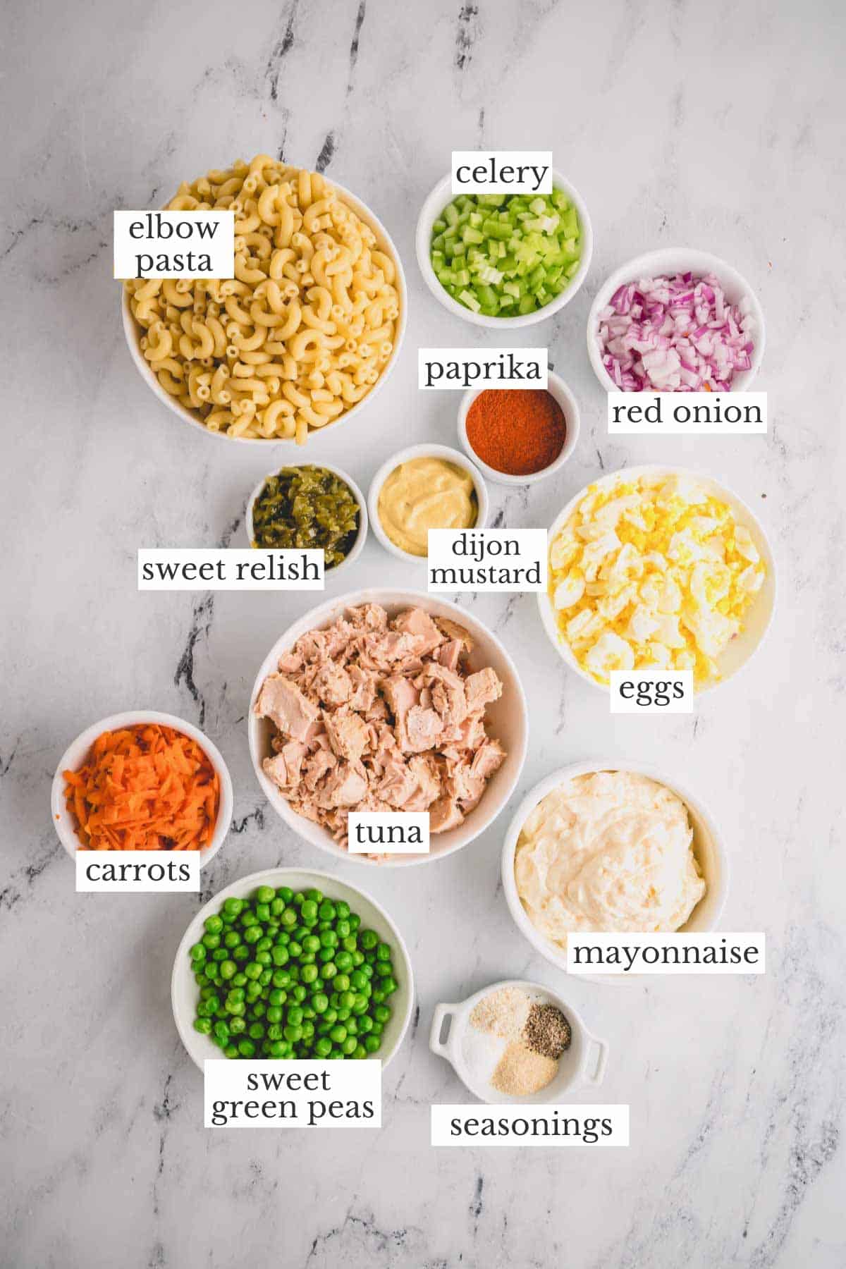 Bowls of ingredients needed to make tuna macaroni salad.