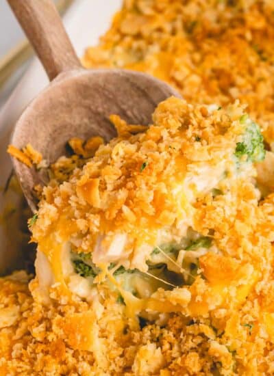 A wooden spoon scooping up a serving of chicken and broccoli casserole.