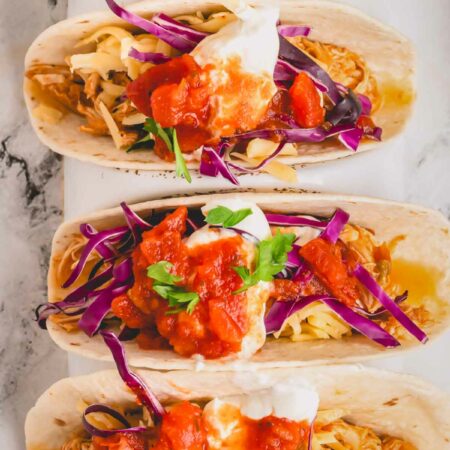 Overhead image of four slow cooker chicken tacos.