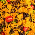 Close up image of a Dorito taco salad recipe with ground beef and black beans.