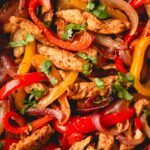 A chicken fajita mixture with chicken, onions, and peppers.