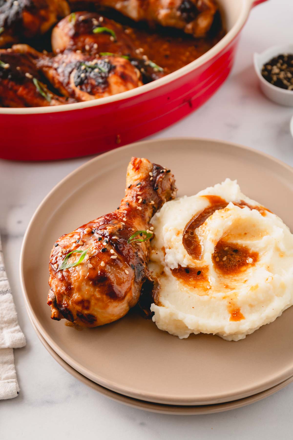 A miso chicken drumstick on a plate with mashed potatoes.