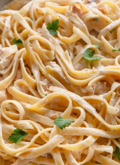 Close view of smoked salmon fettuccine topped with fresh parsley.