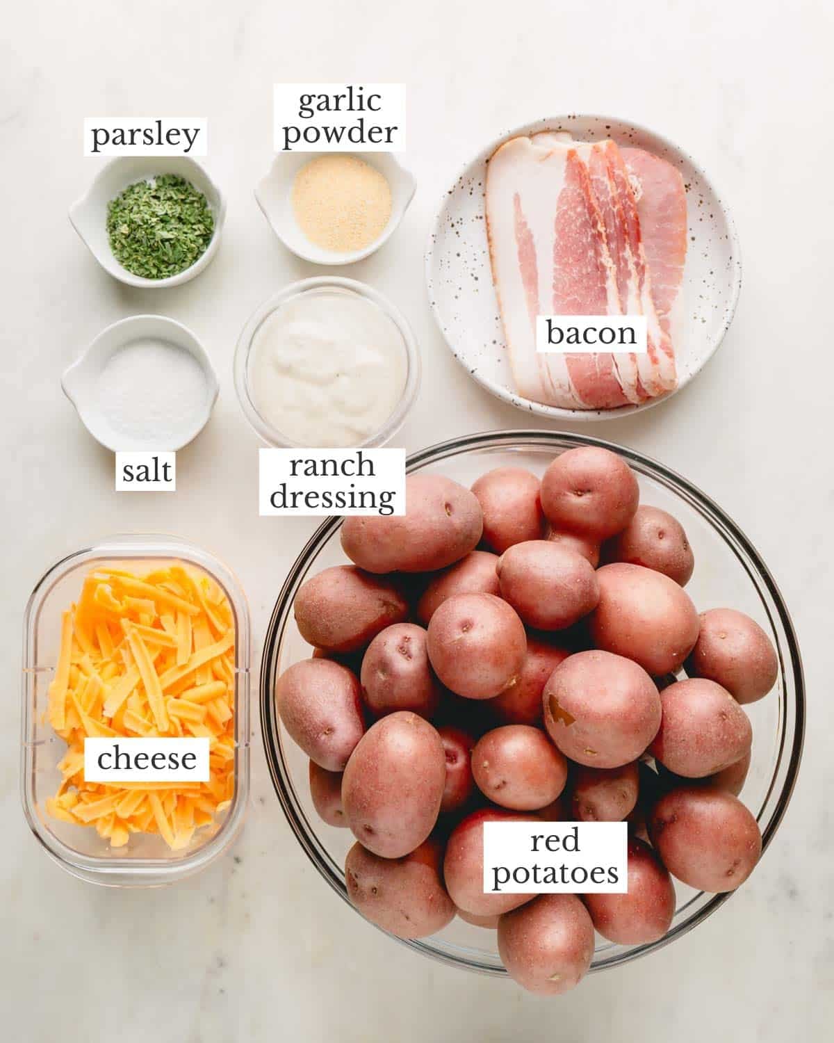 Ingredients in individual bowls for cheesy bacon ranch potatoes.