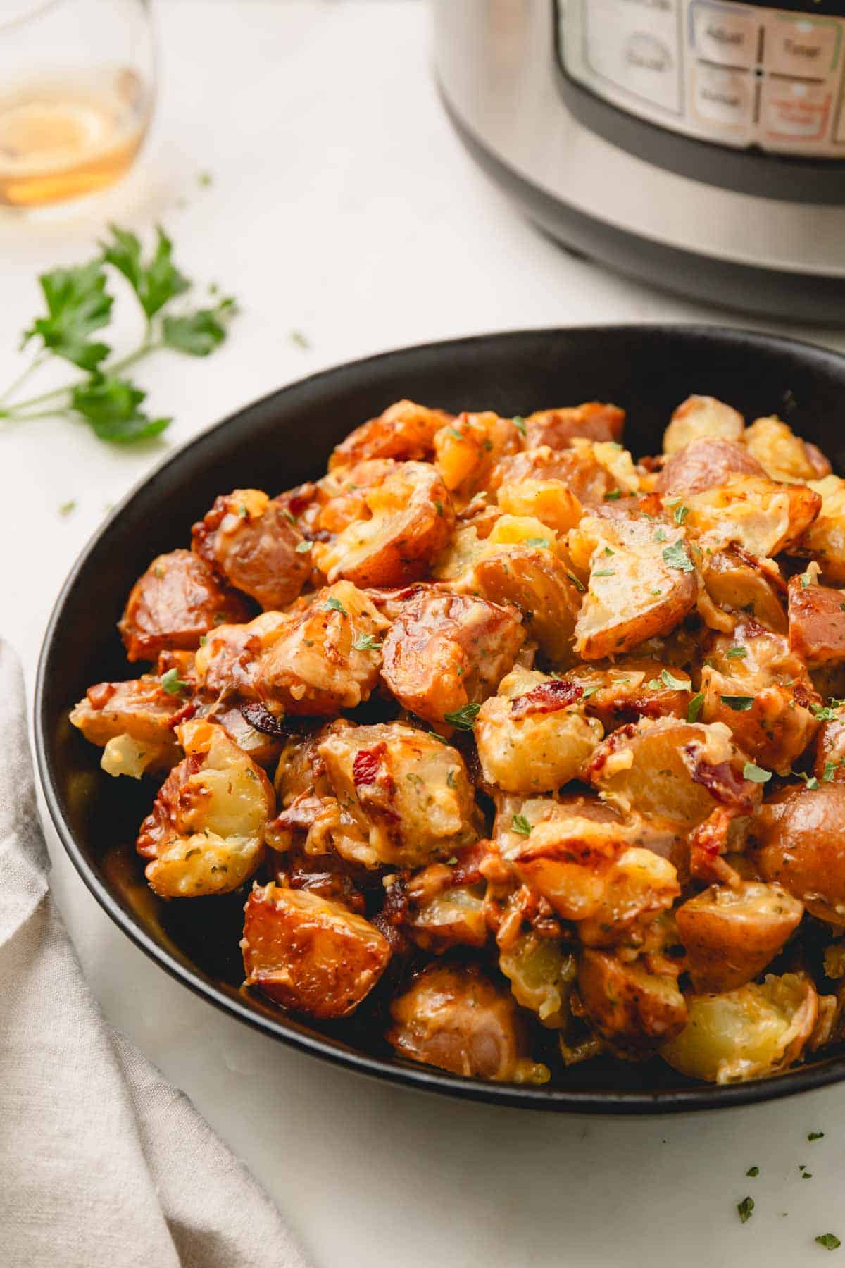 Bacon ranch potatoes in a large black serving bowl.