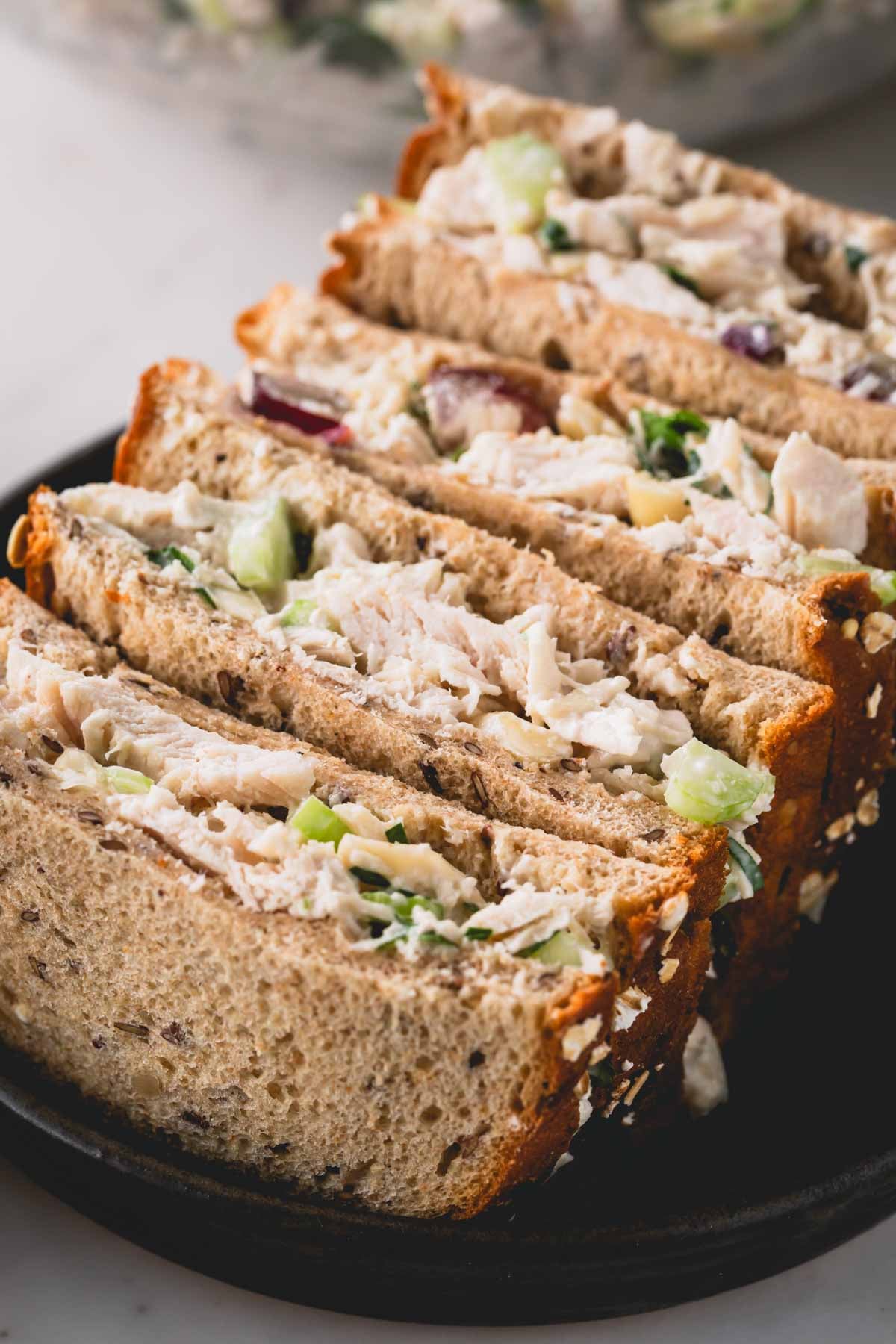 Four chicken salad sandwich halves.