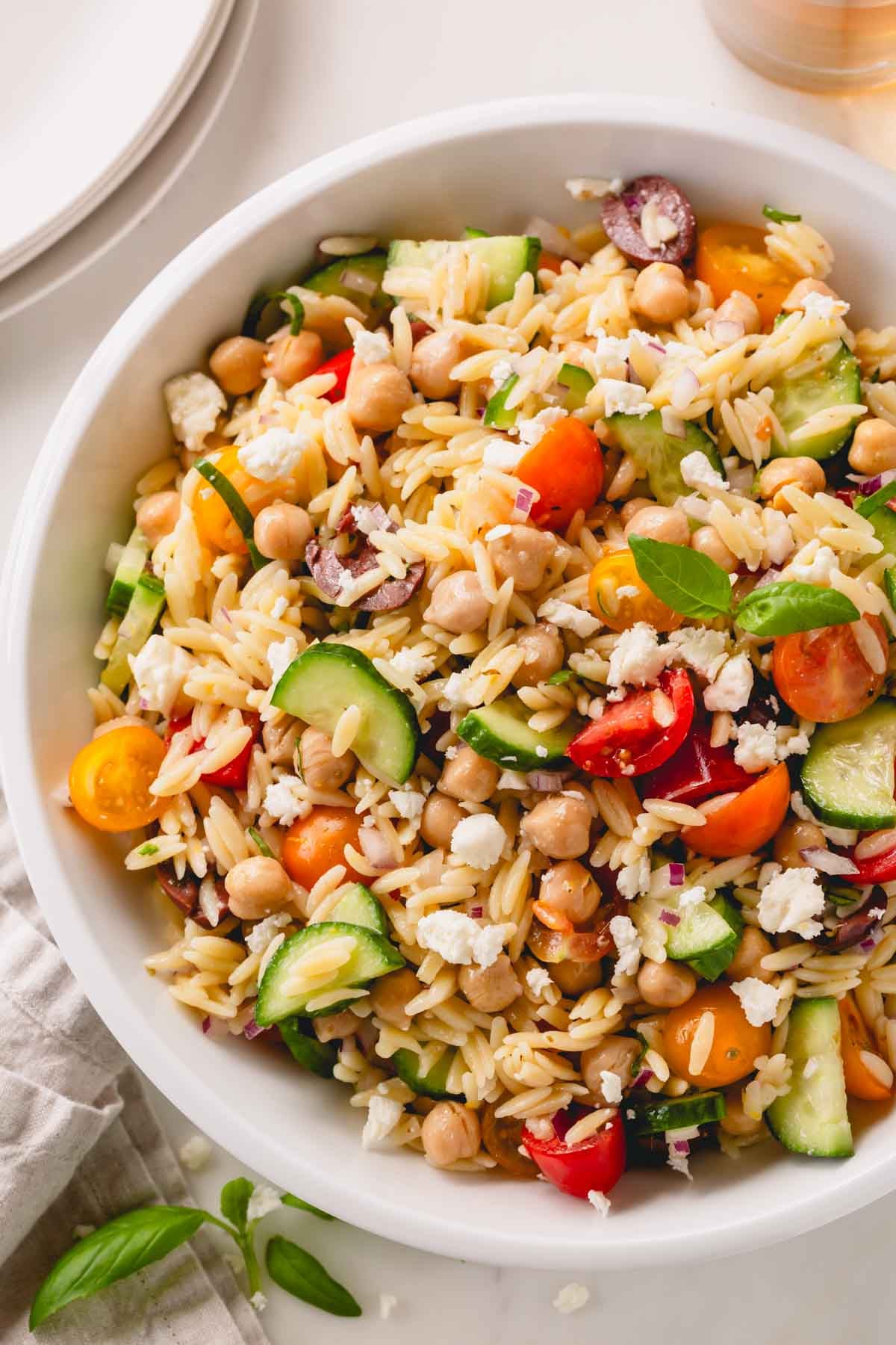 A white bowl of orzo salad.