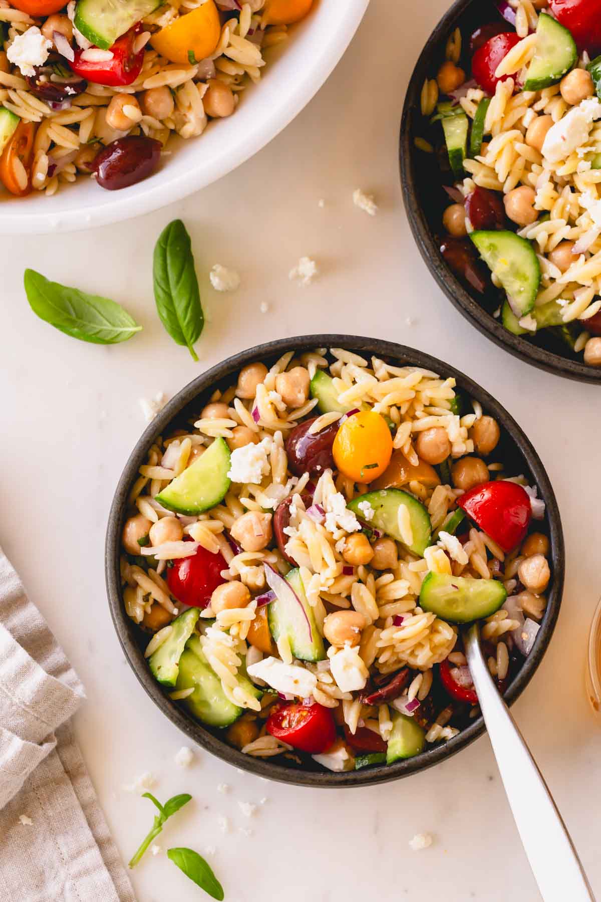 A small bowl of orzo salad with a fork sticking out.