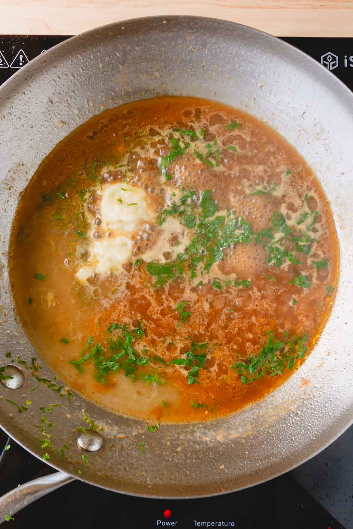 Chicken broth, lime juice, zest, cilantro, and garlic are added to the now-empty skillet.