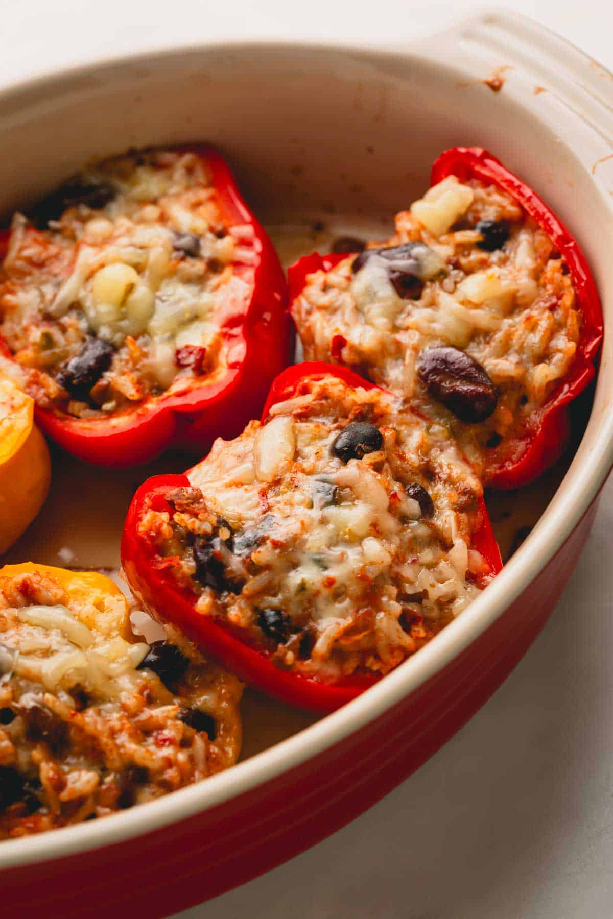 A casserole dish full of cheesy chili stuffed bell peppers.