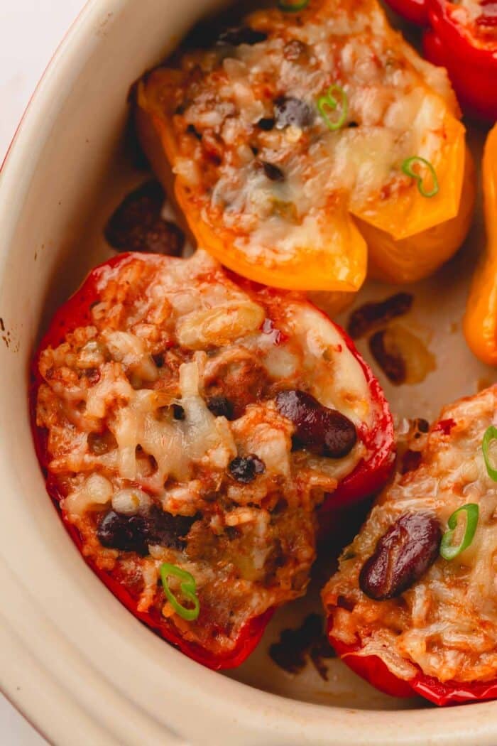 Cheesy chili stuffed bell pepper halves in a baking dish.