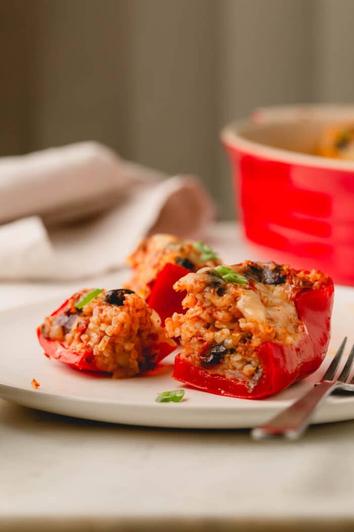 A cheesy chili stuffed bell pepper on a plate with a fork.