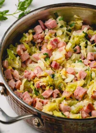 Ham and cabbage is in a large saute pan.