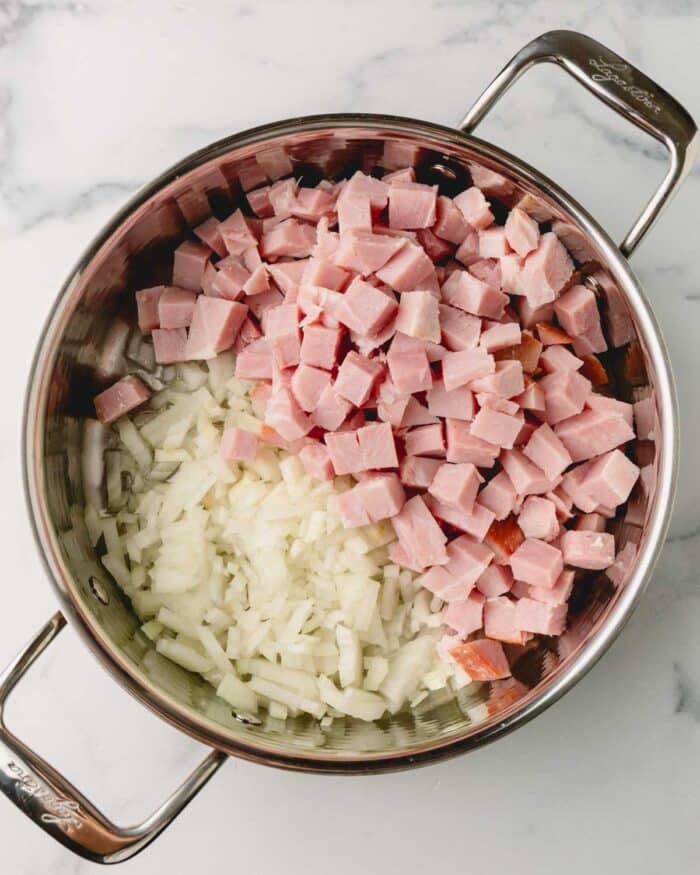 Onion and ham are in a large saute pan.