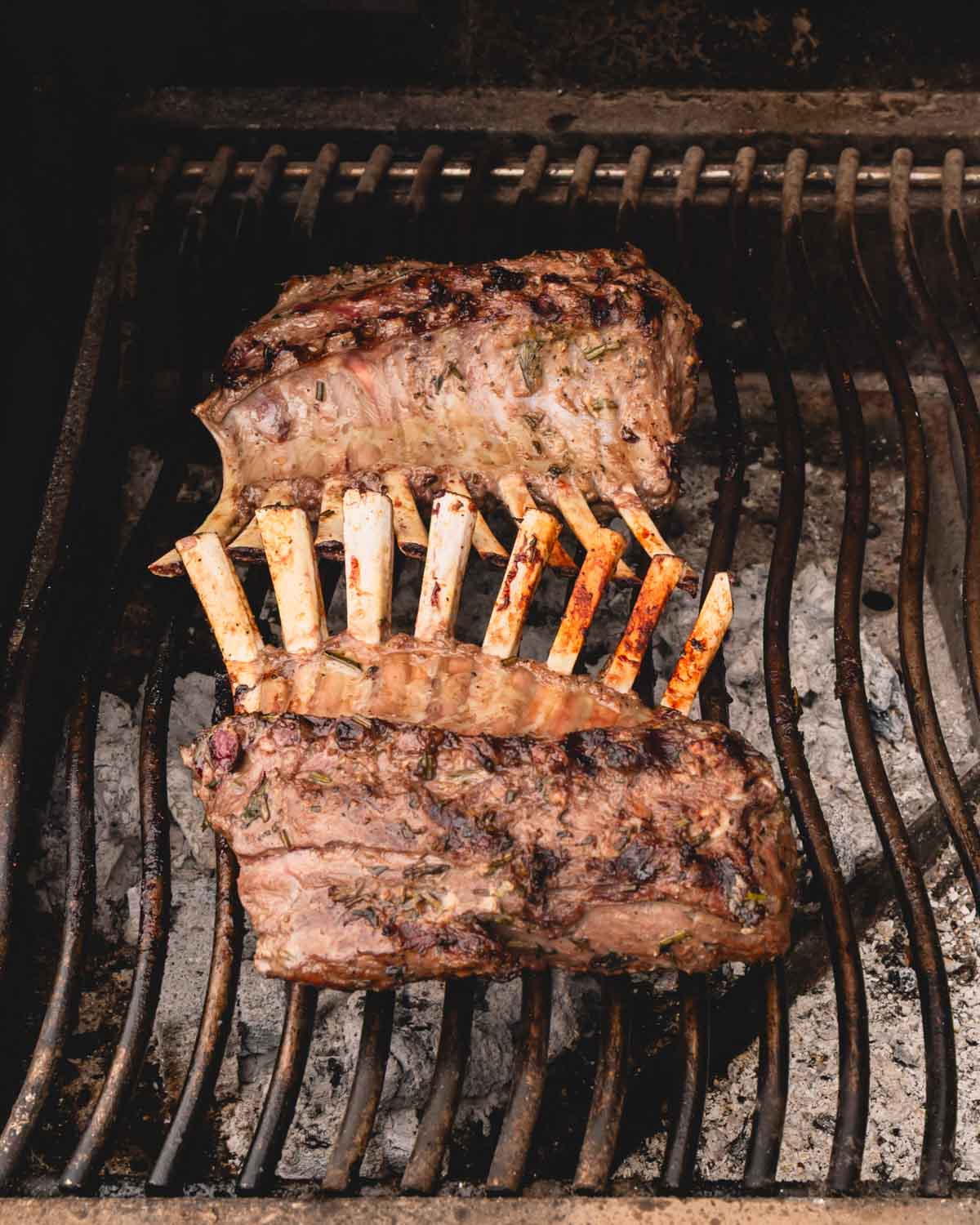 Two racks of lamb are grilling.