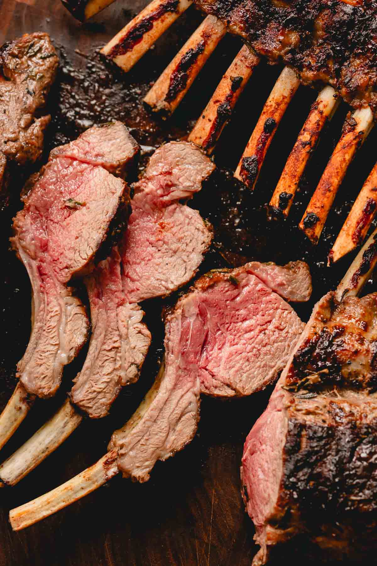 A grilled rack of lamb is cut into individual chops.