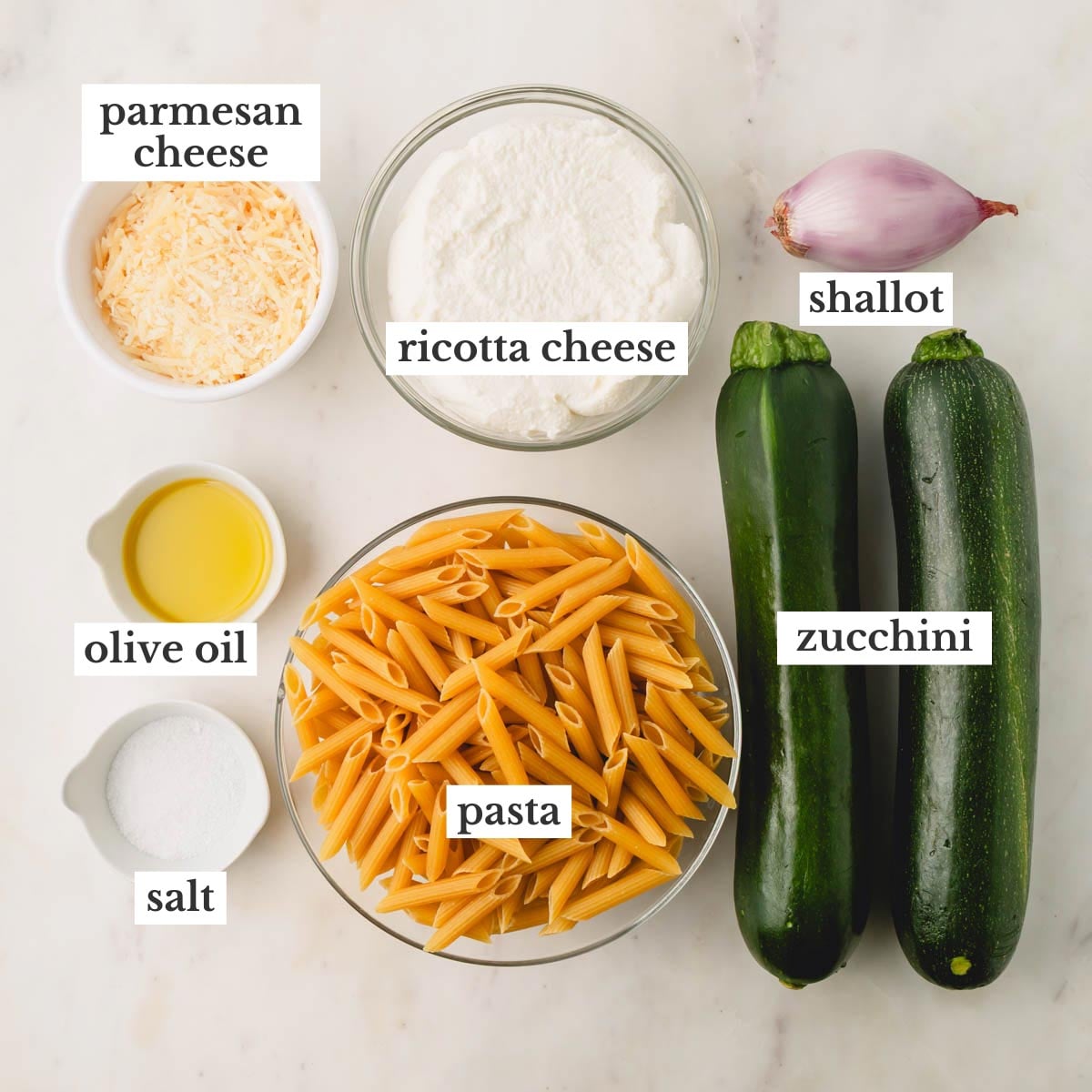 Ingredients for zucchini ricotta pasta which include parmesan cheese, olive oil, ricotta, pasta, shallot, zucchini, and salt.