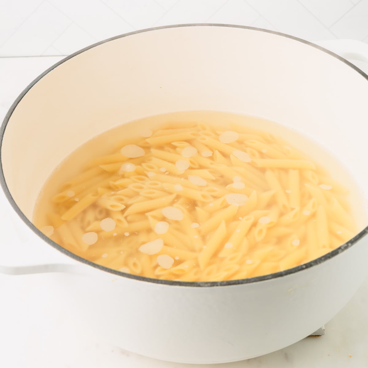 Pasta boiling in a large white pot.