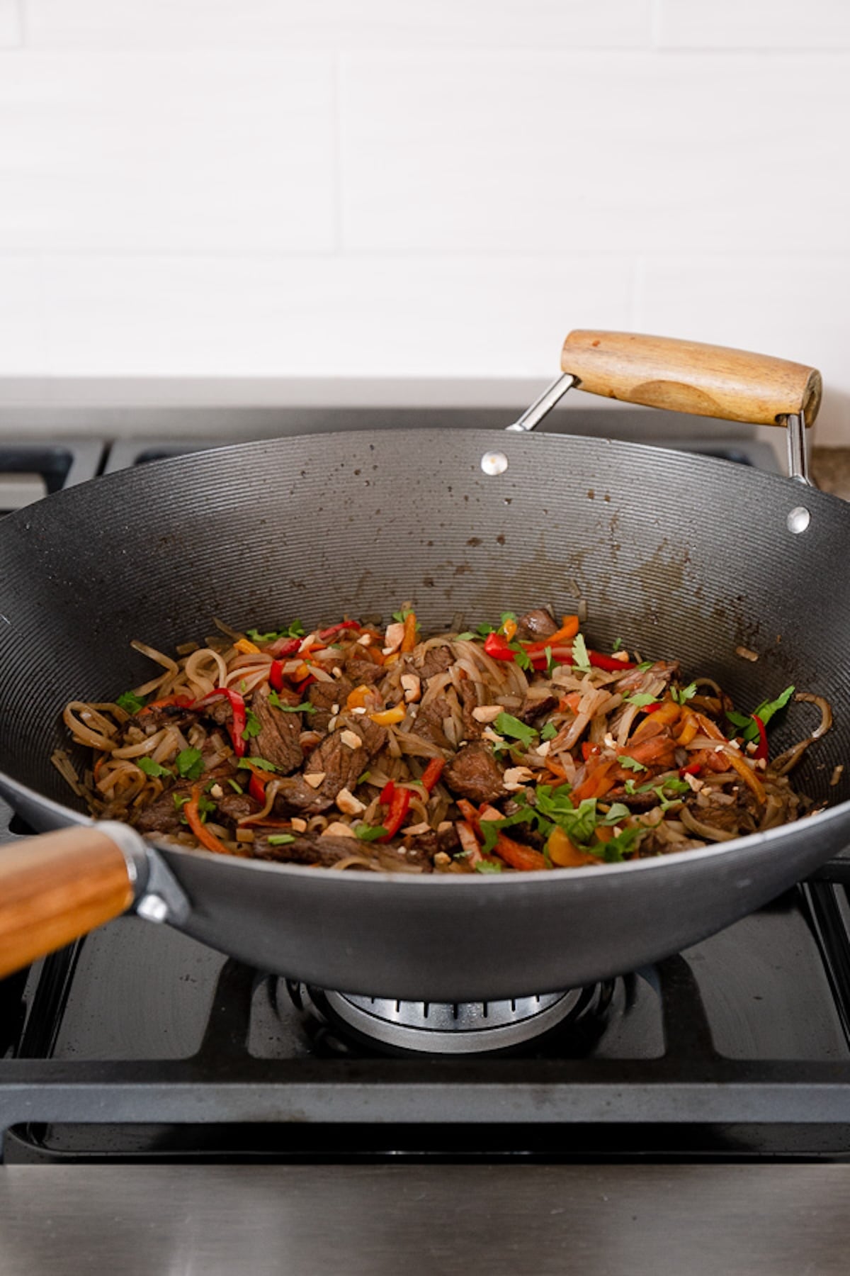 Beef pad thai is cooking in the wok.