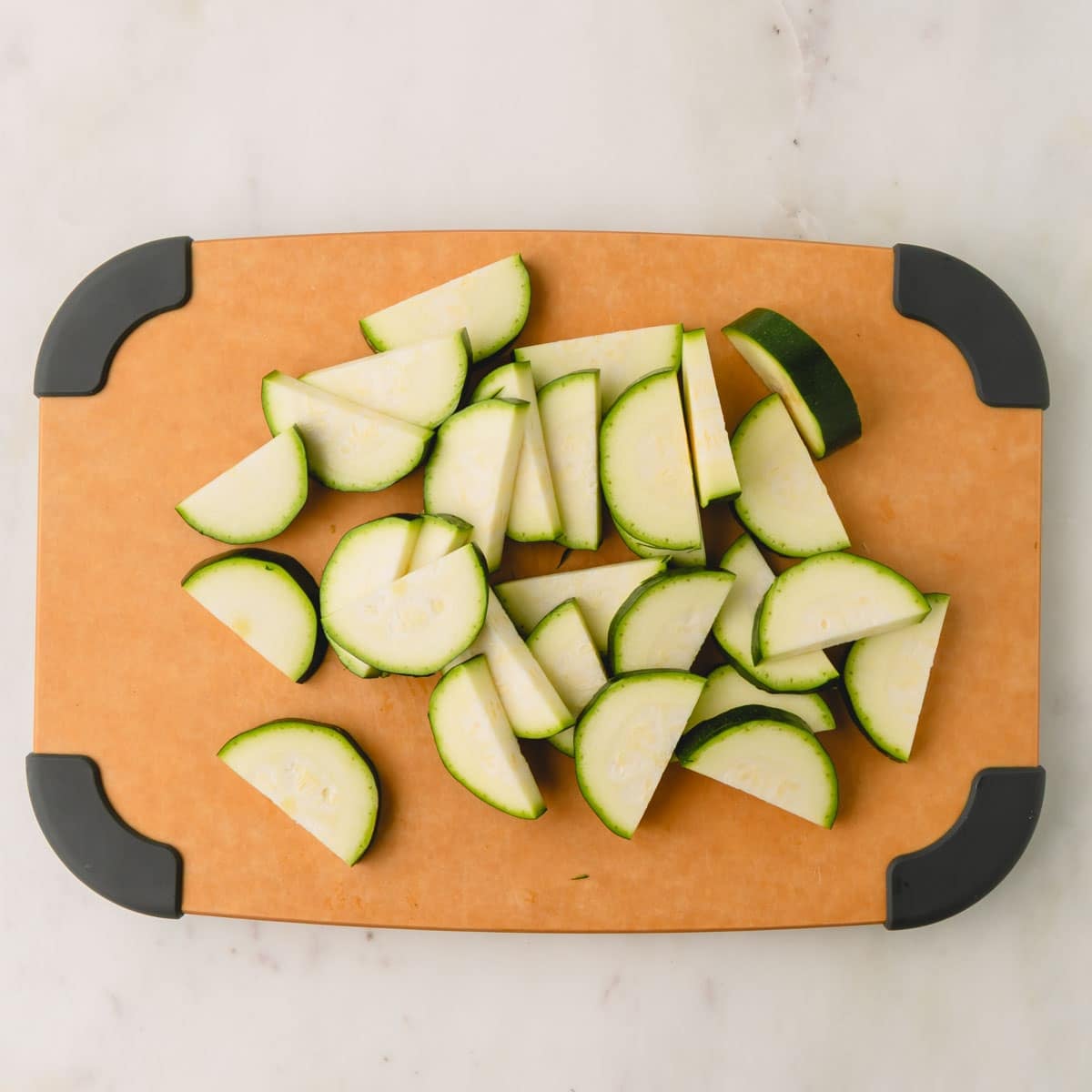 Zucchini cut into half circles on a cutting board.