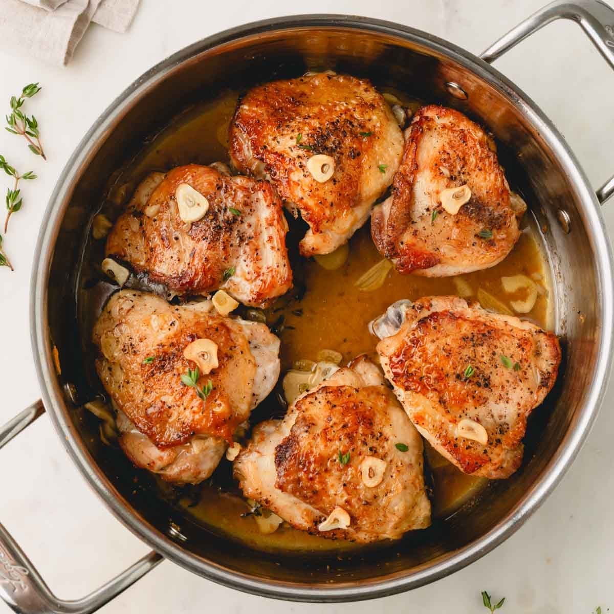 Garlic butter chicken thighs are in a skillet.