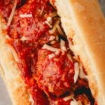 A closeup image of meatballs without breadcrumbs in a sub sandwich.