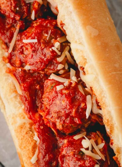 A closeup image of meatballs without breadcrumbs in a sub sandwich.